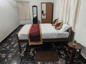 a bedroom with a bed and a table and a mirror at Thulir Farm Stay Near Isha Yoga Adiyogi in Coimbatore