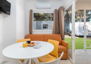a living room with a white table and yellow chairs at Ostuni Torre Pozzelle Open Air in Ostuni Costa Merlata
