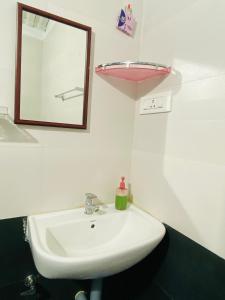 a bathroom with a white sink and a mirror at Thulir Farm Stay Near Isha Yoga Adiyogi in Coimbatore +23 photos