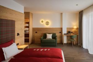 a bedroom with a bed and a desk and a chair at Hotel Mesdi in Arabba +51 photos