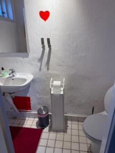 a bathroom with a toilet and a heart on the wall at Stanza in zona turistica in Hirtshals