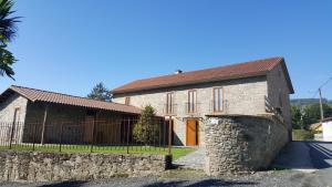 ein Steinhaus mit einem Zaun davor in der Unterkunft Casa da Paioca in Paleo