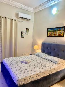 a bedroom with a bed with a blue head board at Résidence NECTAR 2 in Abidjan