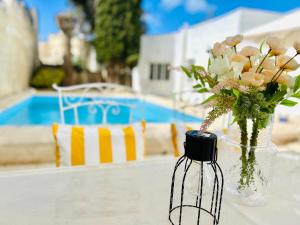 a vase with flowers in it sitting on a table at Panoramic Ocean View Villa in Is-Swieqi