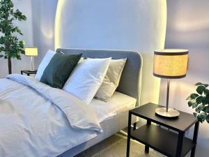 a blue couch with pillows and a table with a lamp at Panoramic Ocean View Villa in Is-Swieqi