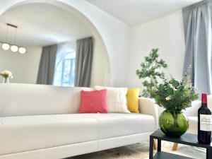 a living room with a white couch with colorful pillows at Panoramic Ocean View Villa in Is-Swieqi