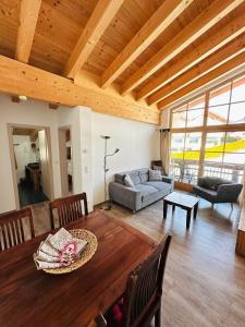 a living room with a table and a couch at Landhaus Bergglühen inkl Bergbahnticket in Oberjoch
