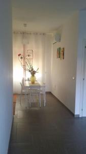 a white room with a table with a vase on it at B&B Stefyld in Paola +26 photos