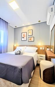 a bedroom with a large bed and a desk at Apto 2/4 com Wi-Fi, TV, piscina e garagem | 1402 in Campinas +31 photos
