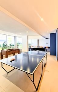 a ping pong table in a living room at Apto 2/4 com Wi-Fi, TV, piscina e garagem | 1402 in Campinas