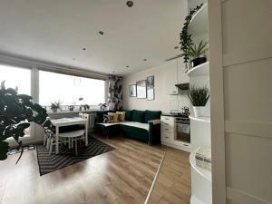 a kitchen and living room with a green couch and a table at Mazury Witaj in Ostróda +3 photos