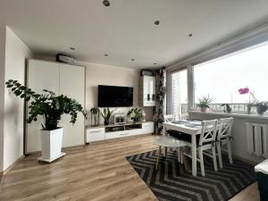 a living room with a table and chairs and a television at Mazury Witaj in Ostróda