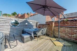 a patio with an umbrella and a table and chairs at 3 Bed in Lincoln oc-a30207 in Lincoln