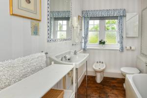 a bathroom with a tub and a sink and a toilet at 4 Bed in Abersoch oc-trefab in Abersoch