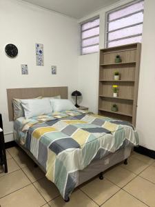 a bedroom with a bed and a book shelf at AeroloftGT in Estación Pamplona
