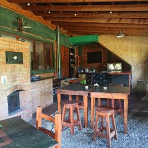 a room with a table and chairs and a fireplace at Hostal del río in El Bolsón