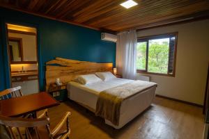 a bedroom with a bed and a table and a sink at Grande Hotel Canela in Canela