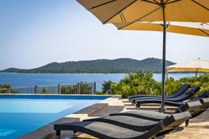 a swimming pool with lounge chairs and an umbrella at Camp Panorama Plus with Pool in Drage