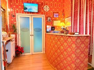 an office with an orange wall with a desk and a counter at Hotel magnolia 1000 mt dal casello in Valmontone