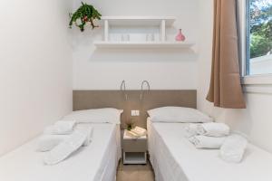 two beds sitting next to each other in a room at Ostuni Torre Pozzelle Open Air in Ostuni Costa Merlata +25 photos
