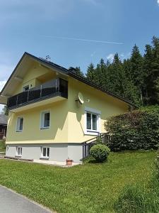 a yellow and white house with a green yard at Sonja´s Ferienwohnung in Patergassen