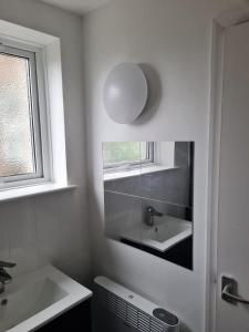 a white bathroom with a sink and a mirror at 1 Bedroom Flat Ground Floor - Central Dunstable in Dunstable