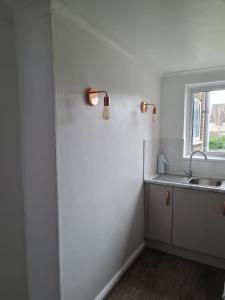 a white kitchen with a sink and a window at 1 Bedroom Flat Ground Floor - Central Dunstable in Dunstable