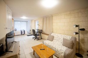 a living room with a couch and a table at La suite d'Amanda-wifi-jardin NO KITCHEN in Villefranche-de-Rouergue