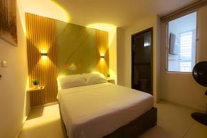a bedroom with a bed and a window and lights at hermoso apartasuite con la mejor ubicación in Cartago