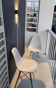 two white chairs in a room with stairs at hermoso apartasuite con la mejor ubicación in Cartago