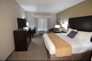 a hotel room with a large bed and a desk at New Roads River Hotel in New Roads