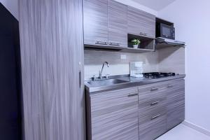 a kitchen with a sink and a stove at hermoso apartasuite con la mejor ubicación in Cartago