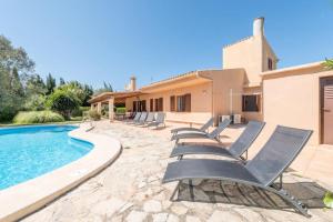 a villa with a swimming pool and lounge chairs at Villa Canescandeu in Port de Pollensa