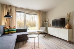 a living room with a couch and a tv at Appartement De Jutter, Resort Amelander Kaap in Hollum