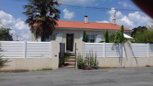 a white fence in front of a white house at Chambres d'hôtes La Rose Des Sables in Les Herbiers