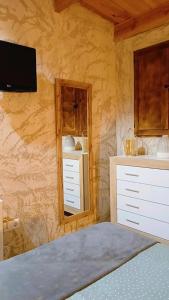 a bedroom with a bed and a mirror and a tv at Casita Sol in Villafamés
