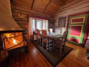 a dining room with a fireplace and a table and chairs at Idyllisk feriested in Gol