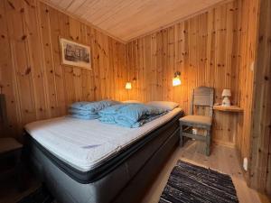 a bedroom with a bed in a wooden wall at Idyllisk feriested in Gol