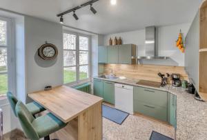 a kitchen with green cabinets and a wooden counter top at Maison de Charme a Rémy in Rémy