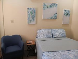 a bedroom with a bed and a blue chair at Cozy Kingston Flat in Kingston