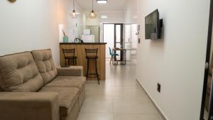 a living room with a couch and a kitchen at Jahu Center Casas Un 3 in Jaú