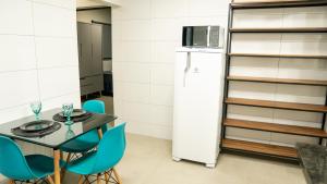 a kitchen with a table and a refrigerator at Jahu Center Casas Un 3 in Jaú