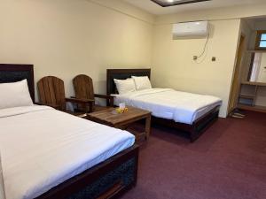 a hotel room with two beds and a table and chairs at KOH E QAF HUNZA in Hini +17 photos