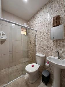 a bathroom with a toilet and a sink and a shower at Mangut in São Miguel dos Milagres +6 photos