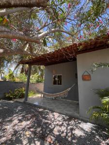 a house with a hammock in front of it at Mangut in São Miguel dos Milagres