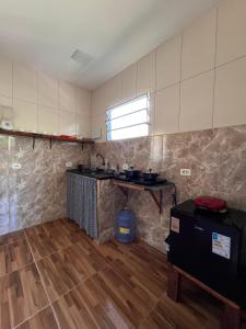 a kitchen with a sink and a table in a room at Mangut in São Miguel dos Milagres