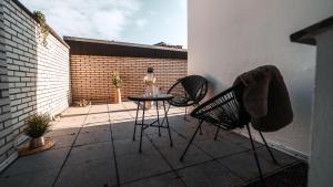 a patio with two chairs and a table with a bottle at FlexHome Stadtnatur Ferienwohnung in Lippstadt