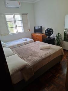 a bedroom with two twin beds and a window at Pousada Lua Nova in Sorocaba