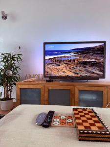 a table with a television and a chess board and remote controls at Sunset Beach House in Zambujeira do Mar