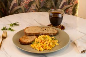 a plate of eggs and toast and a glass of soda at Hotel Ambala Bogota Colonial in Bogotá